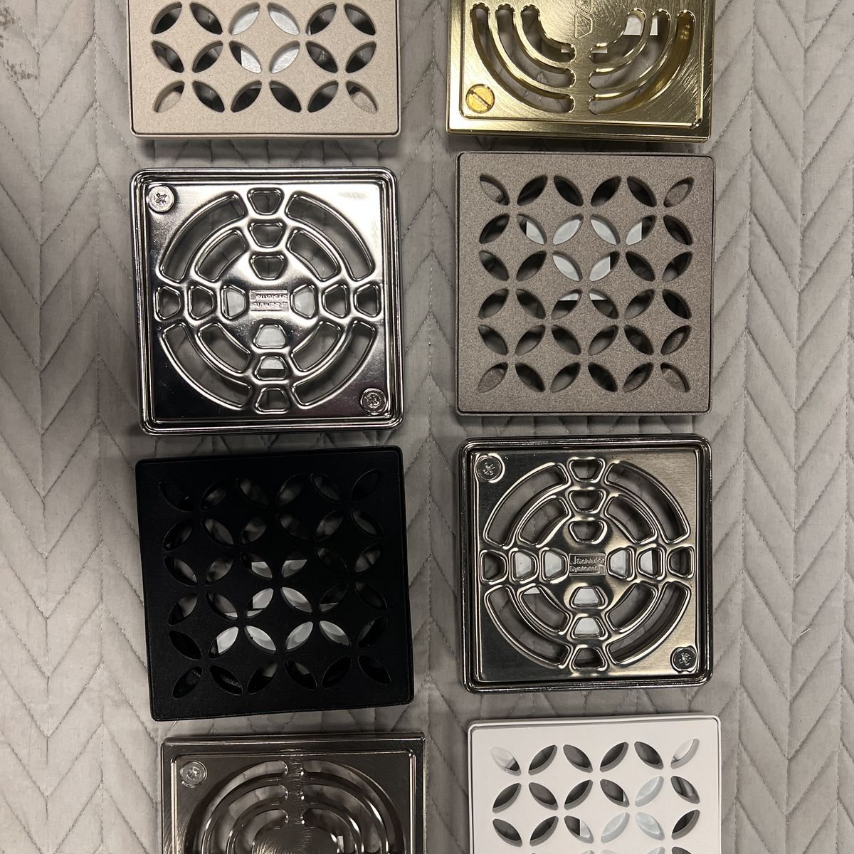 Schluter shower drain covers in stainless, black, and brass at Evansville Tile Distributors